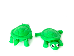 Two green plastic toy turtles on white.
